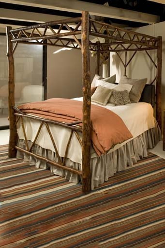 blue mountain bed with four posters, canopy, and branch accents