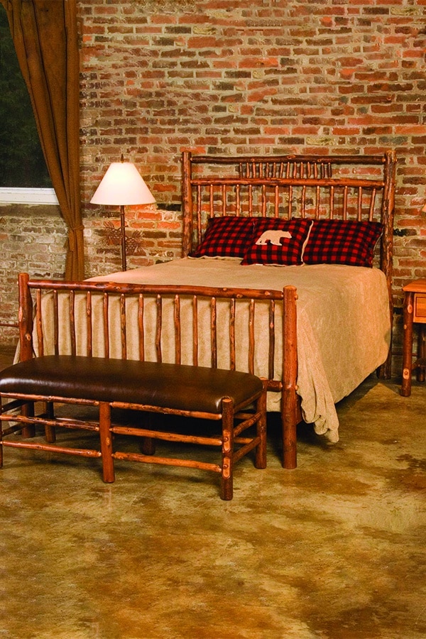 rustic log craft bed with leather upholstered bench at foot