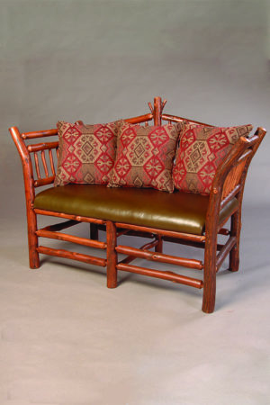 jonas ridge settee for two people with leather seat and red pillows