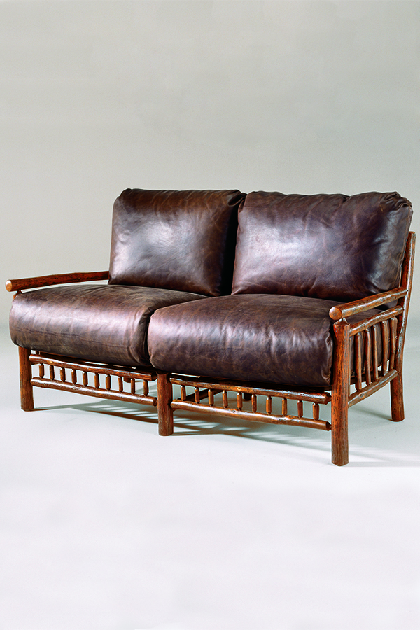 rustic wood loveseat with brown leather cushions