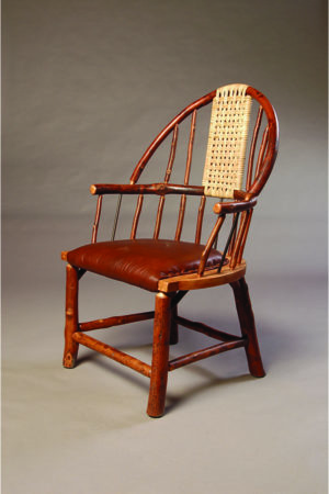 windsor chair with curved wooden back , woven accent, and leather seat