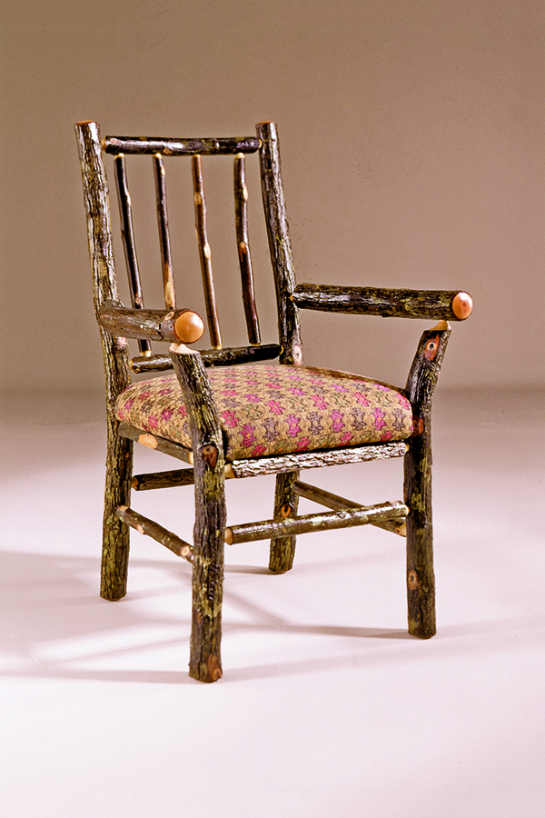 arm chair with bark log frame and patterned fabric seat
