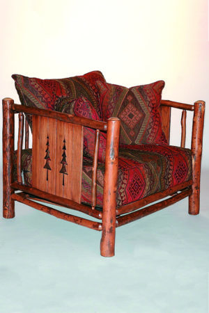 pine tree club chair with carved trees, red and brown pattered upholstery and pillows